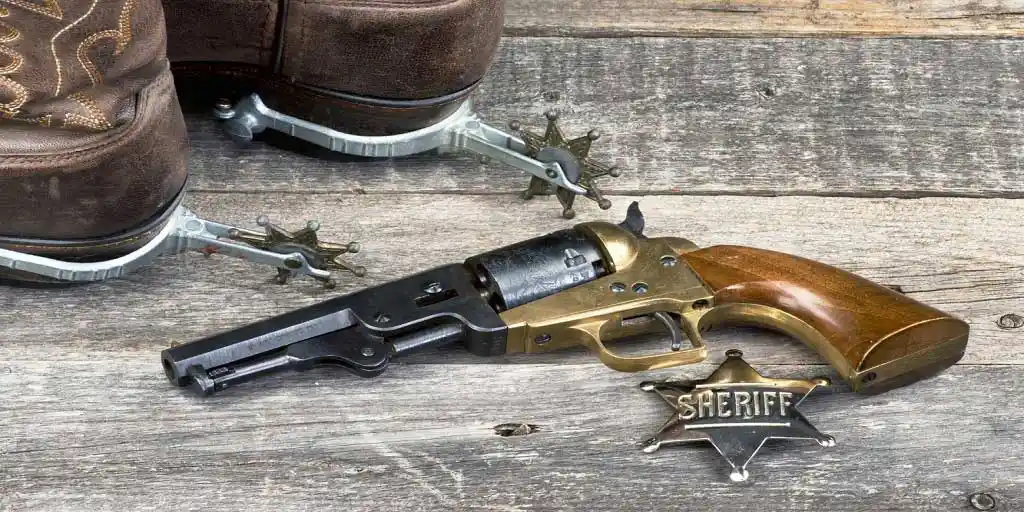 1849 pocket revolver with cowboy boots and spurs